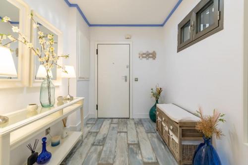 a room with a white door and a table with vases at ApartUP Patacona Azzure in Valencia