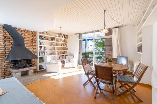 ein Wohnzimmer mit einem Tisch, Stühlen und einem Kamin in der Unterkunft Mediterranean Way - Seaside Tarragona in Tarragona