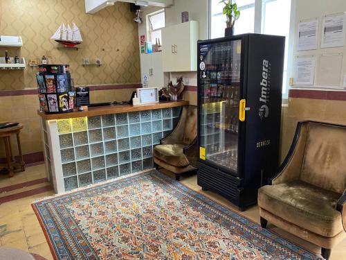 a large soda machine in a bar with two chairs at Mala Vecindad Beer Hotel in Mexico City