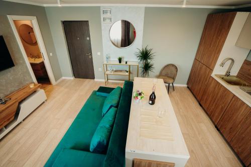 sala de estar con sofá verde y mesa en Smart Studio 76 en Onești
