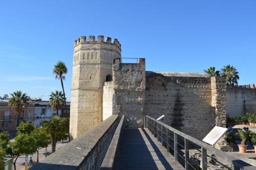 a bridge leading to a castle with palm trees at Hotel Carlos V Jerez by Vivere Stays in Jerez de la Frontera