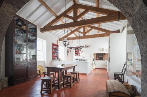 a kitchen and dining room with a table and chairs at Solar de Santo André in Ponta Delgada