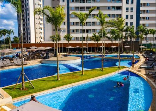 uma vista sobre uma piscina com palmeiras e edifícios em Resort Solar das Águas em Olímpia