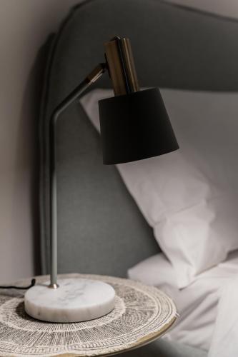 a lamp sitting on a table next to a bed at Palazzo Marzionna in Polignano a Mare