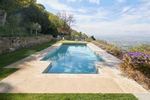 een zwembad in het midden van een tuin bij Villa Bobolino in Cortona