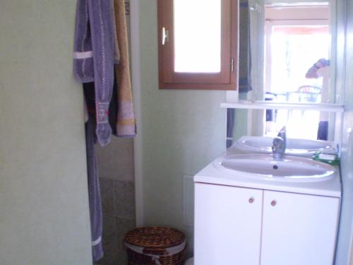 baño con lavabo y ventana en Gîte les Roziers, en Montmurat