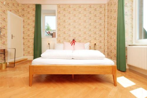 a bedroom with a white bed with green walls at Hotel Beau Séjour Lucerne in Luzern
