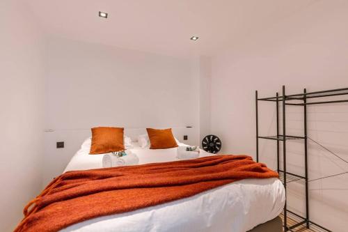 ein Schlafzimmer mit einem Bett mit einer orangefarbenen Decke in der Unterkunft Cozy apartment with beautiful seaview in Knokke-Heist