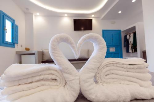 two towel swans sitting on a bed in a room at Perissa Bay in Perissa