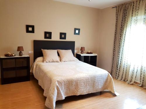 a bedroom with a bed and two tables with lamps at 5 bedrooms villa with private pool enclosed garden and wifi at Ubriquea in Ubrique
