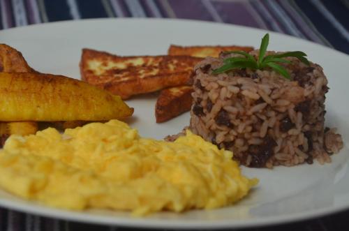 a plate of food with scrambled eggs and toast at Nuestra Casa in San Juan del Sur