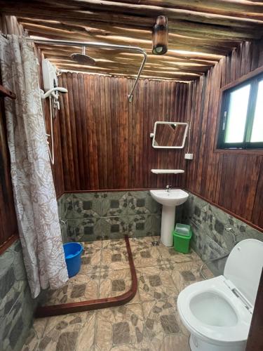 a bathroom with a toilet and a sink at Babaland in New Agutaya