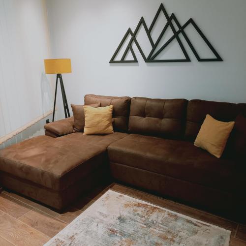 un sofá de cuero marrón en la sala de estar en Garnet Star Apartments, Kopaonik, apartman br 2, en Kopaonik