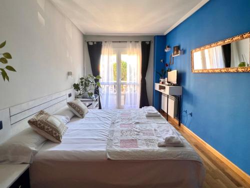 ein Schlafzimmer mit einem großen Bett mit blauer Wand in der Unterkunft Housingleon- Casa Oliva con Garaje in León