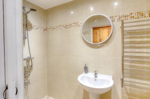 a bathroom with a sink and a mirror at Woodbury Cottage in Woodbury