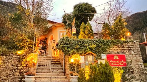 una casa con escaleras y un cartel en ella en Anerada inn Suites & Villa - Pet Friendly, en Karpenisi