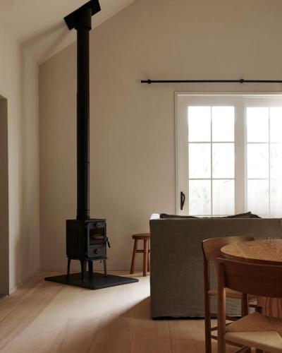 a living room with a wood stove in a room at Inness in Accord