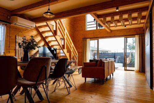 a dining room and living room with a table and chairs at IZA近江舞子 in Minami-komatsu