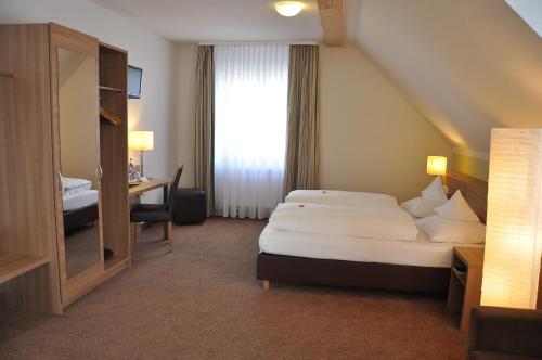 a hotel room with a bed and a desk at Landhaus Kaiser in Abenberg