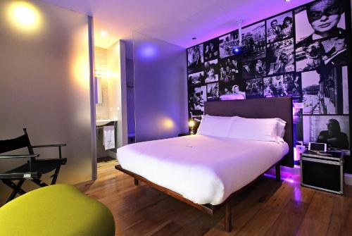 a bedroom with a large white bed with purple lighting at Wrooms Guest House in Rome