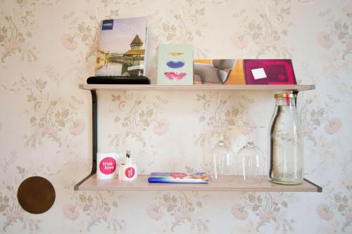 a shelf with a bottle and glasses on a wall at Hotel Beau Séjour Lucerne in Luzern