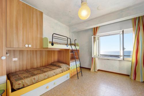 um quarto com um beliche e uma janela em Casa Fronte mare em Arma di Taggia