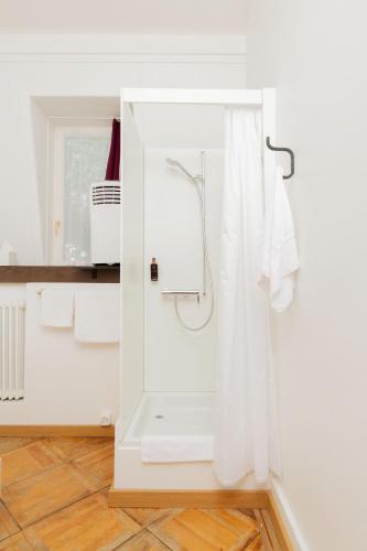 a white bathroom with a shower and a toilet at Hotel Beau Séjour Lucerne in Luzern