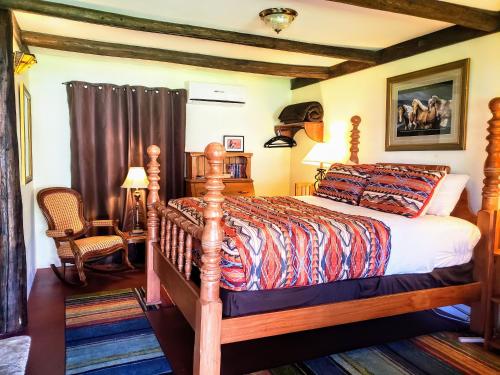 una camera da letto con un letto di legno in una stanza di Rancho Santa Cruz a Tubac