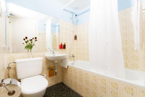 a bathroom with a toilet and a sink and a tub at Hotel Beau Séjour Lucerne in Luzern