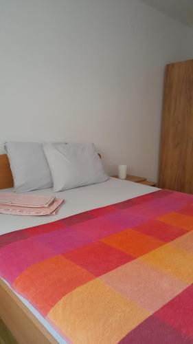 - un lit avec une couverture colorée dans l'établissement Apartman Sunce, à Požarevac