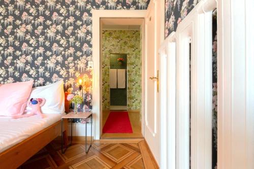 a bedroom with a bed with a floral wallpaper at Hotel Beau Séjour Lucerne in Luzern