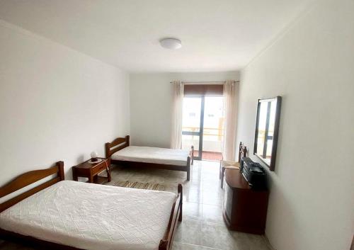 a bedroom with two beds and a mirror and a window at Algarve Apartment Manta Rota in Vila Nova de Cacela
