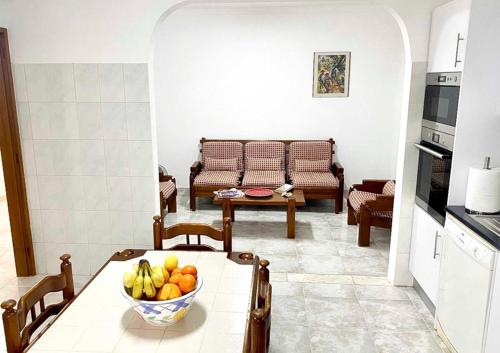 a kitchen with a table with a bowl of fruit on it at Algarve Apartment Manta Rota in Vila Nova de Cacela