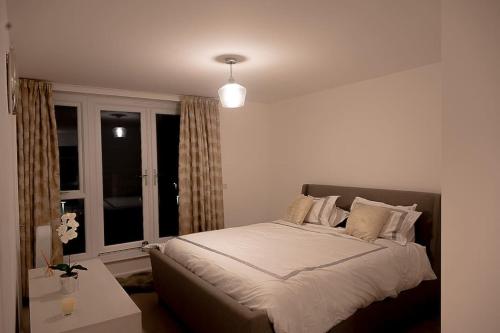 1 dormitorio con 1 cama grande y ventana en Exquisite cozy house, close to Train Station and amenities en Harold Wood