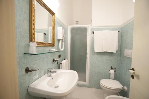 a bathroom with a sink and a toilet and a mirror at Palazzo Senape De Pace in Gallipoli