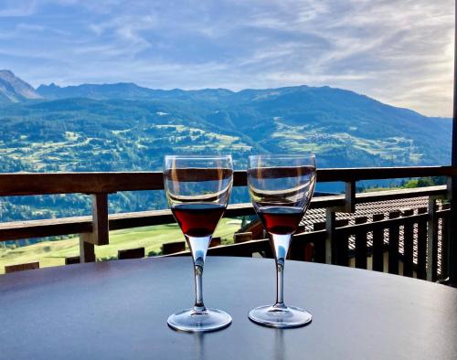 dos copas de vino sentadas en una mesa en Just 10min from Lenzerheide - Apartment in Vazerol, en Brienz