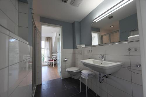 a bathroom with a sink and a toilet and a mirror at Ferienhaus Christina in Bad Windsheim