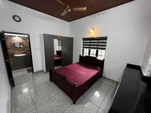 Schlafzimmer mit einem roten Bett und einem Waschbecken in der Unterkunft Munnar Home stay in Munnar