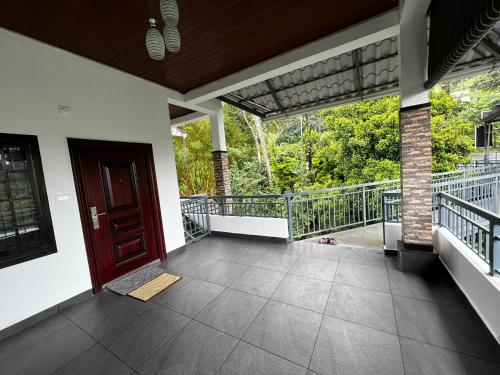 a porch of a house with a red door at Cherry blossom homestays Munnar 2BHK in Munnar