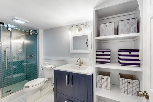 y baño con aseo, lavabo y ducha. en Perfect Cape Cottage en Falmouth