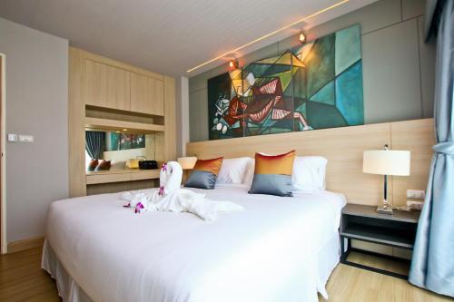 a bedroom with a large white bed in a room at Le Breeze Resort Hua hin in Cha Am