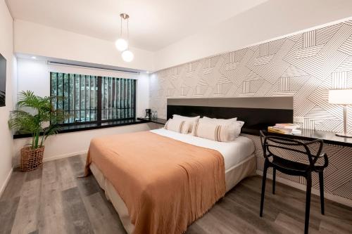 1 dormitorio con 1 cama grande, escritorio y ventana en Top Rentals Montañeses en Buenos Aires