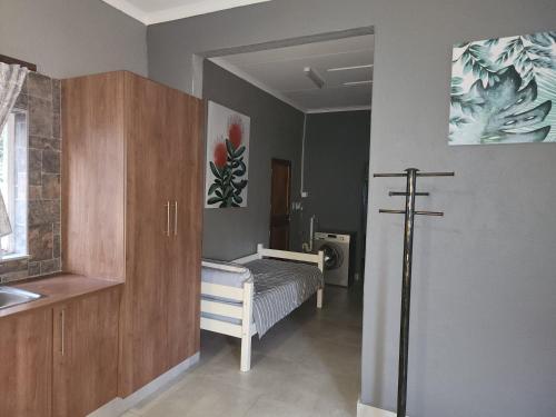 een kamer met een bed en een kruis aan de muur bij Le Grix Guesthouse in Nelspruit