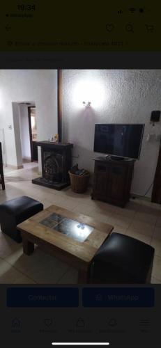sala de estar con mesa de centro y TV en FloChris Villa Gesell Zona Norte SÓLO FAMILIAS en Villa Gesell