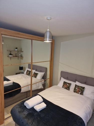 a bedroom with two beds and a mirror at Sunny House in Haydock