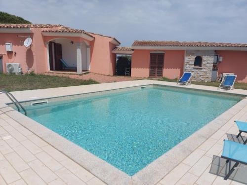 a swimming pool in front of a house at Gallura Dream villas in Budoni