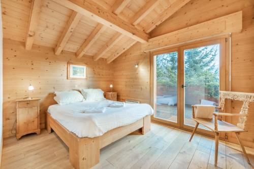 een slaapkamer in een blokhut met een bed en een raam bij CT in Verbier