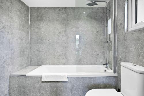 a bathroom with a tub and a toilet and a sink at Chestnut, 6 Fingle Glen Lodges in Holcombe Burnell