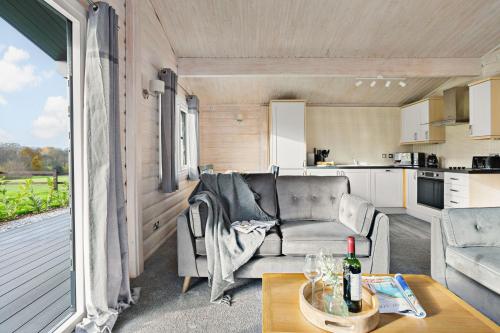 a living room with a couch and a table at Chestnut, 6 Fingle Glen Lodges in Holcombe Burnell