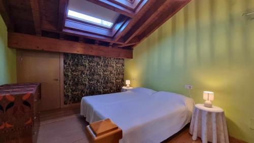 a bedroom with a large white bed and a skylight at Casa Vacacional La Portillina in La Portilla